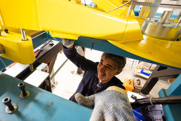 An MIT employee works on a piece of equipment